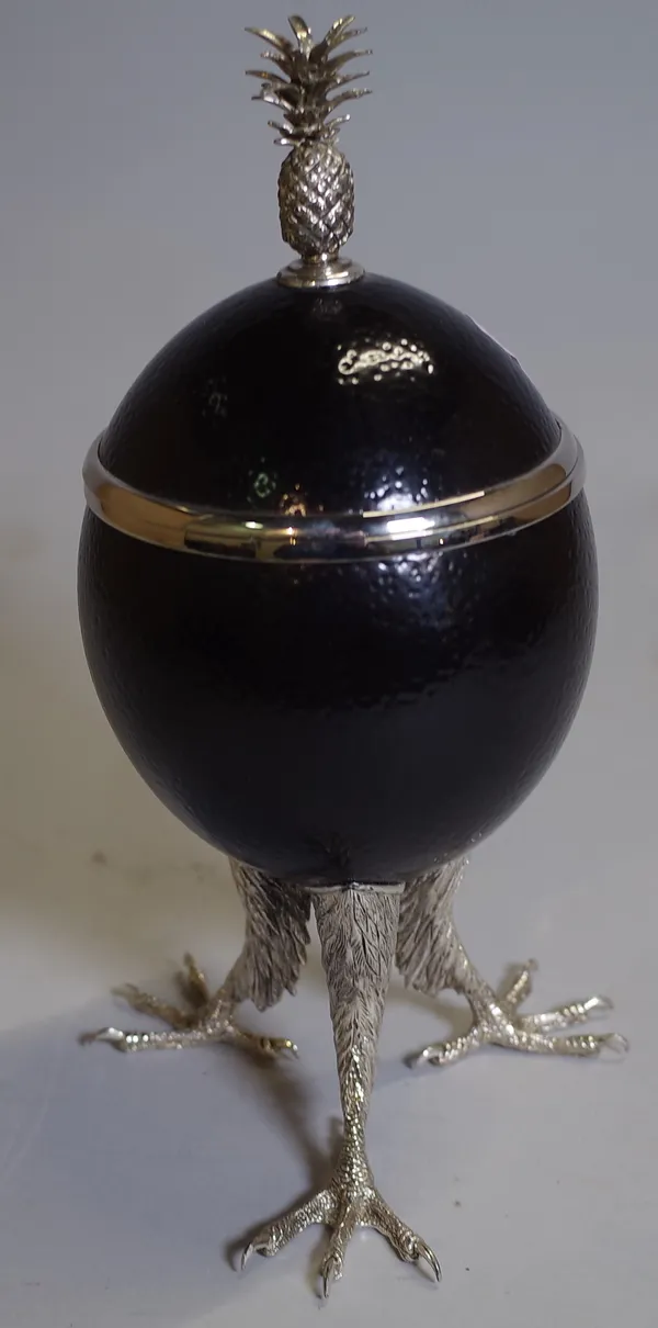 A black painted ostrich egg converted into a lidded trinket pot, with white metal mounts and claw feet, 29cm high.