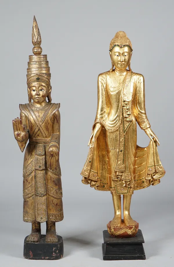 A modern giltwood figure depicting a South East Asian Buddha, inset with green gems on an ebonised plinth, 143cm high and one further similar giltwood