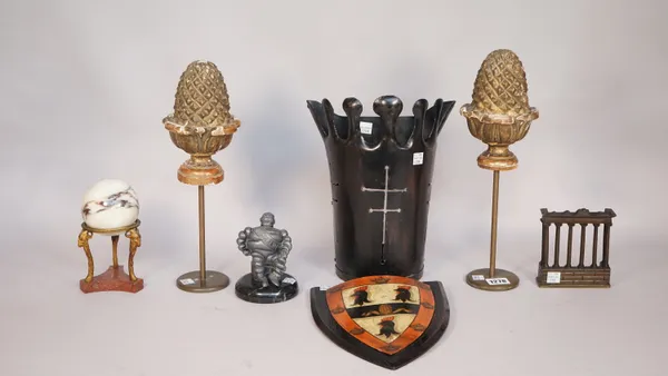 A pair of gilt-wood carved pineapple finials on metal stands, 34cm high, a 19th century marble sphere on stand, 15.5.cm, a heraldic shield on an eboni