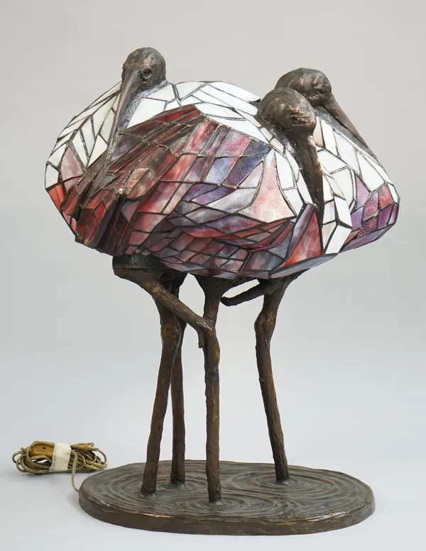 A composite bronze and glass table lamp by Potang Yu Wu, dated 1988, modelled as three cranes in a pond, signed to the case, 70cm overall.