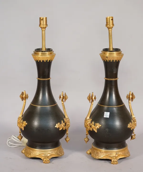 A pair of French bronze and ormolu mounted table lamps, each of two handled vase form, on four lion paw feet, 35cm high, (2).