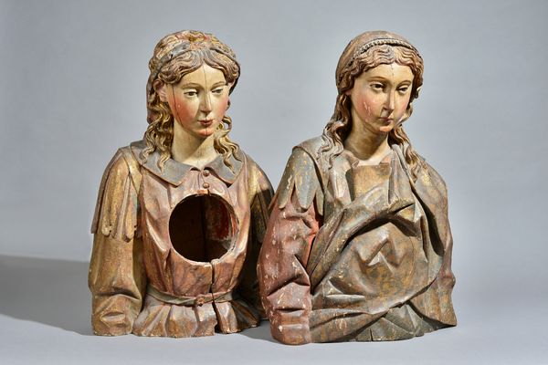 A pair of parcel gilt and polychrome painted wooden busts of female saints, Spanish, 17th century, formerly reliquary busts, each with a later circula