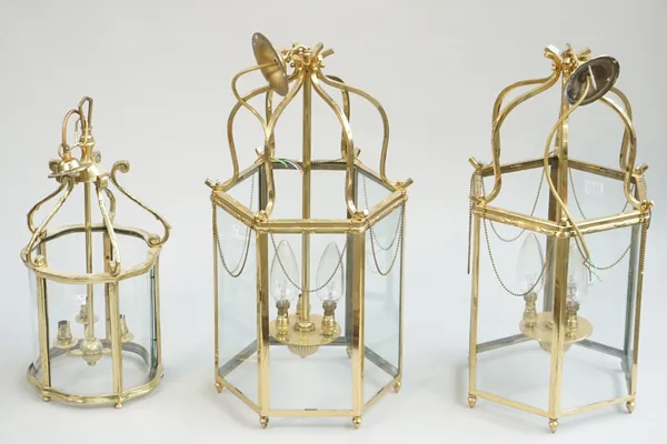 A pair of modern brass hall lanterns of octagonal form, with internal three light fitment, 58cm high and another similar smaller brass hall lantern, 4