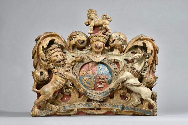 A polychrome painted Royal Warrant, 19th century, relief carved wood and gesso on an ebonised wooden backplate, 59cm wide x 50cm high x 11cm deep. Ill