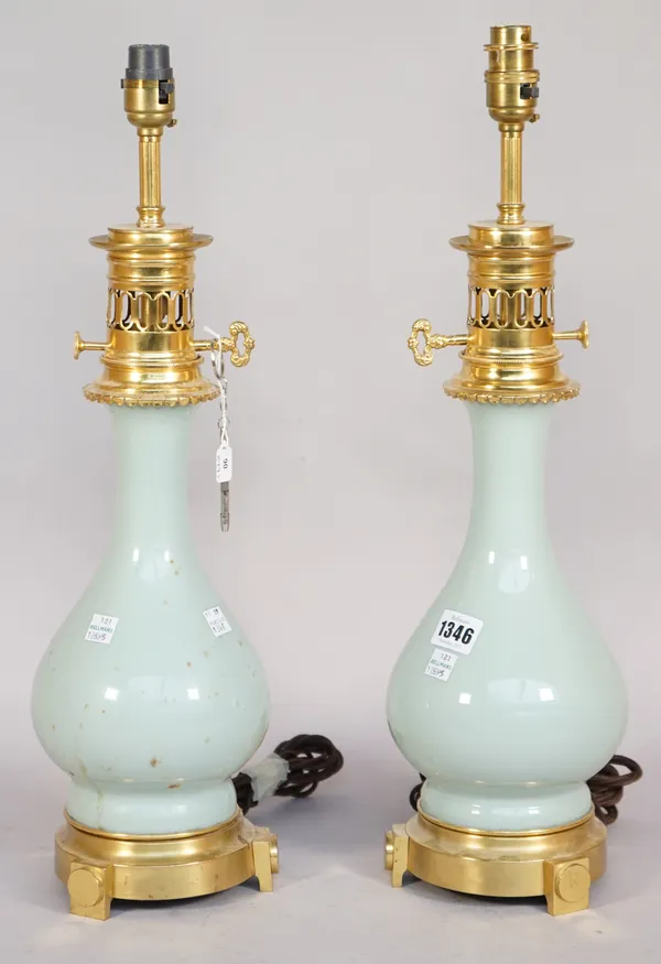 A pair of Chinese style celadon porcelain vase table lamps, late 20th century, each with gilt metal faux oil lamp mounts, 40cm high, (2).