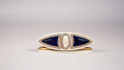 An 18th century ivory toothpick box, of navette form, with central glazed aperture, holding a lock of braided hair flanked by cobalt blue enamelled pa