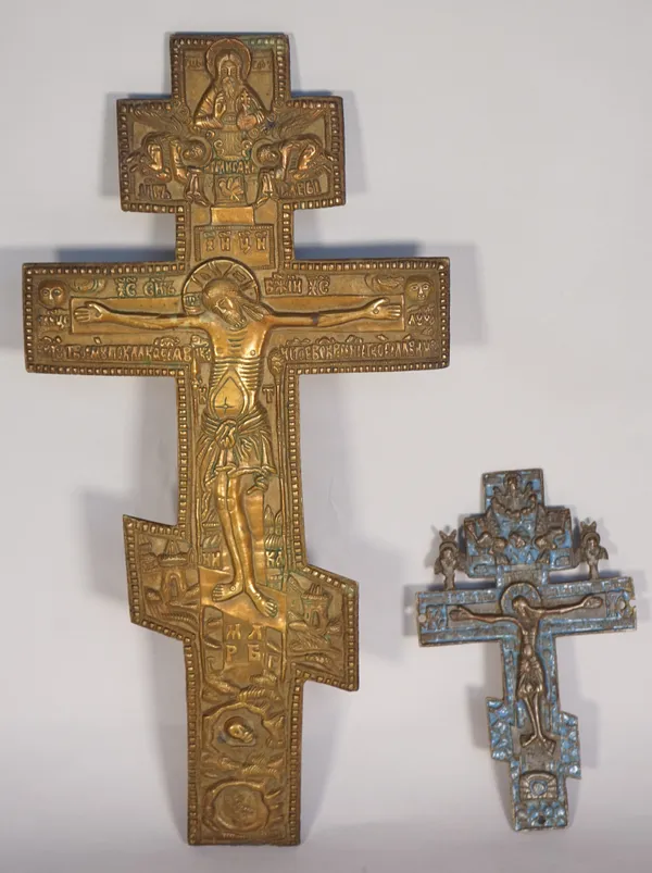 Two brass Russian icons, each relief cast crucifix form, the smaller with traces of blue enamel, 34cm high, (2)