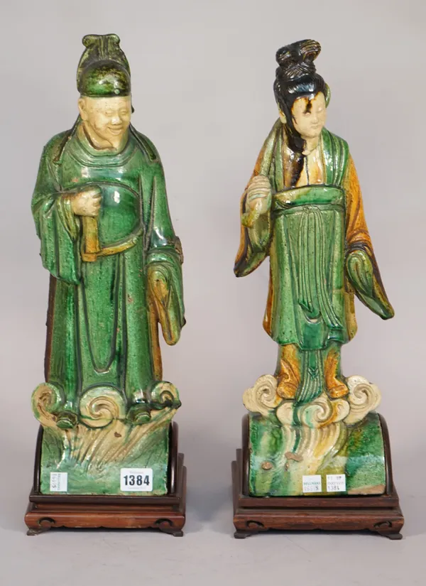 A pair of Chinese pottery figural roof finials, polychrome painted, each on a wooden stand, 44cm high, (2), (a.f.).