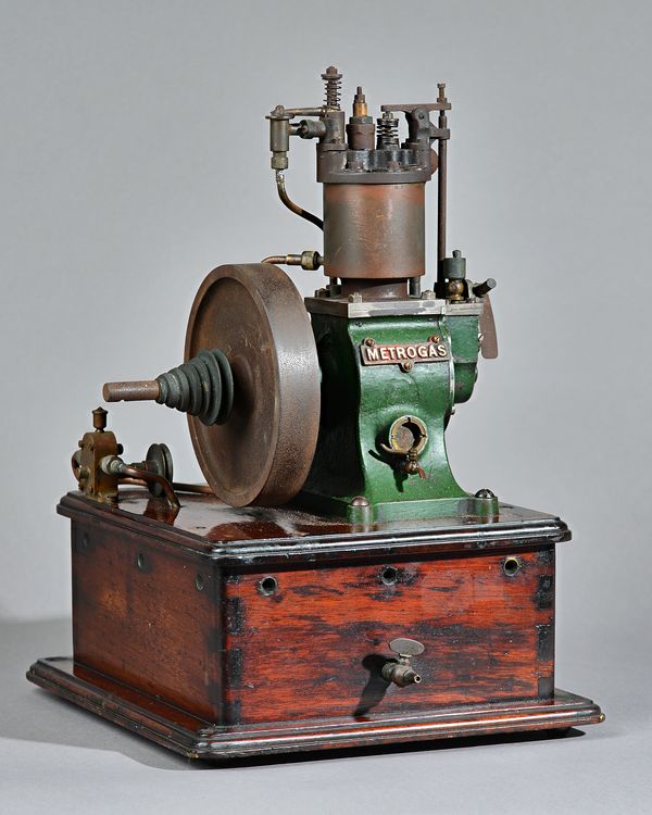 A rare demonstration vertical single cylinder, water cooled, hot tube ignition 'Metrogas' engine, circa 1910, green painted on a mahogany base, 37cm h