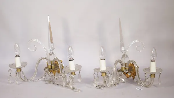 Two sets of four cut moulded and brown glass twin branch wall lights, parts 19th century and later parts, the first set with slice cut scrolling arms