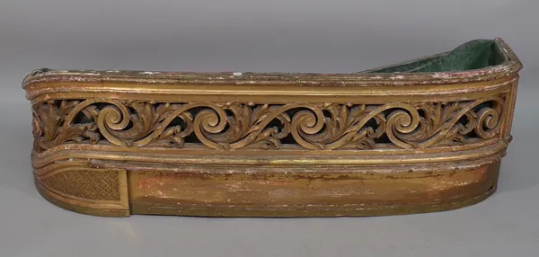 A giltwood planter of asymmetric form, late 19th century, with foliate carved and pierced frieze and a tin liner, 130cm wide.