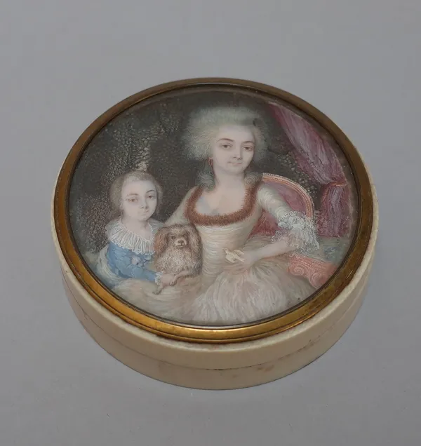 A Continental Italian ivory box and cover, 19th century, the circular lid painted with a family group and dog beneath a brass bezel, (a.f.), 8cm diame