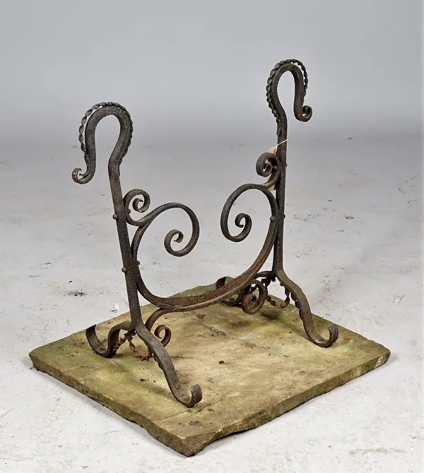 A Victorian wrought iron boot scraper of scroll work form, raised on four shaped feet and a stone plinth, 62cm high.