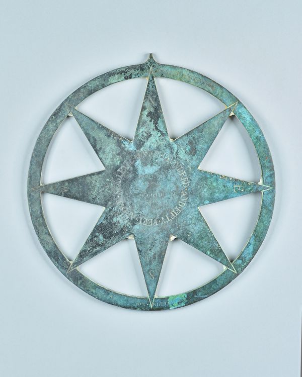 A patinated bronze surveyor's marker, late 19th century, of circular form engraved with compass markers to an eight-pointed central star, engraved to