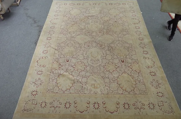 A European carpet, the madder field with an all over fawn large palmette and interconnecting floral design, matching border, 425cm x 306cm.