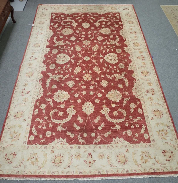 A European carpet, the madder field with large all over floral design, ivory complementary palmette border, 525cm x 306cm.