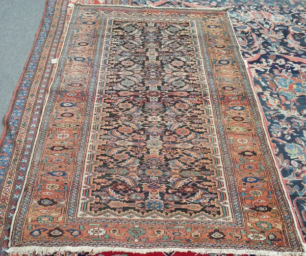 A North West Persian rug. the black field with an allover herate design, a madder flowerhead and wine border, 208cm x 136cm.