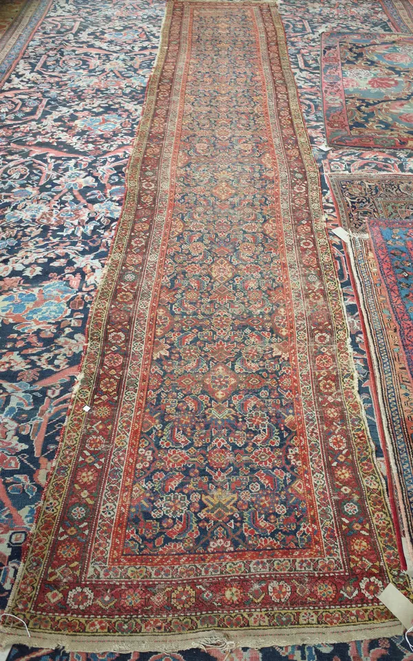 A Fereghan runner, Persian, the indigo field with an all over herate design, a matching rosette border, 474cm x 95cm.