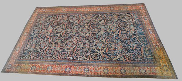 A Fereghan carpet, Persian, the dark indigo field with a central natural bouquet and all over madder leaves and vines and floral bouquets, a madder pa