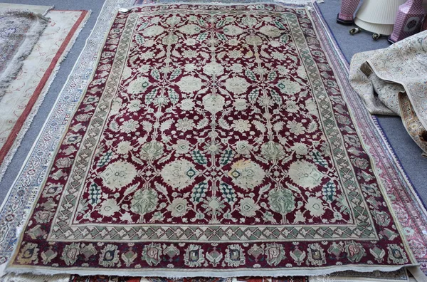 An Amritsar rug, the burgundy field with ivory and sage round flower heads, sprays of flowers; a burgundy flower head border, 250cm x 170cm.