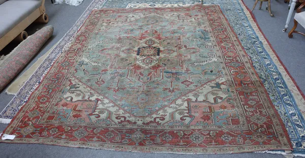 A Heriz carpet Persian, the pale indigo field with a bold madder and sage medallion, ivory and madder spandrels, all with angular vines; a madder rose