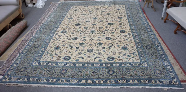 A Kashan carpet, Persian, the ivory field with an allover palmette and floral vine design, a grey palmette and scrolling vine border, 433cm x 300cm.