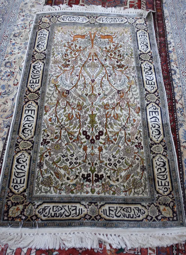 A Chinese silk tree of life rug, the ivory field filled with an abundantly floral tree, inscriptions to border, 153cm x 92cm.