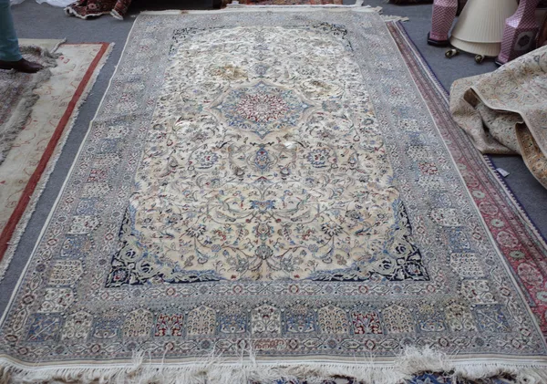 A fine part silk Esfahan rug, Persian, the dark ivory field with a central madder and pale indigo medallion, dark indigo spandrels all with delicate f