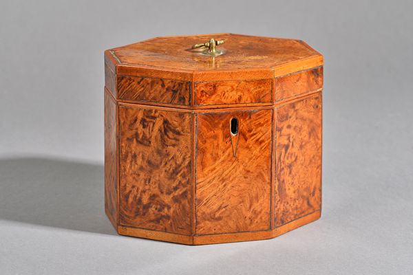 A George III burr yew wood tea caddy of compressed octagonal form, with twin compartment interior, 16cm wide x 13cm high. Illustrated