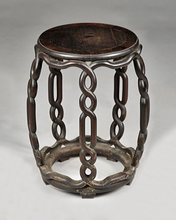 A late 19th century Chinese hardwood barrel stool, with open pierced interlaced supports, 38cm wide x 49cm high.  Provenance; the late Sir David Tang.