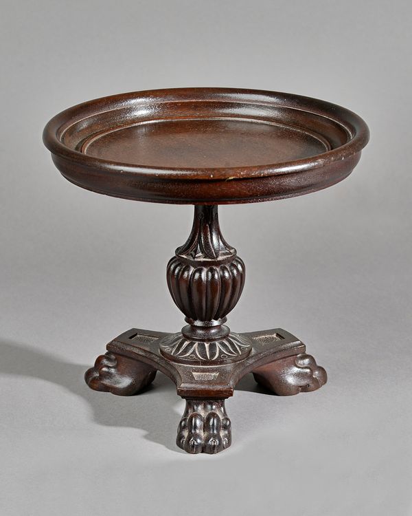 An 18th century style mahogany tazza, the dished circular top on reeded baluster column and three paw feet, 25cm diamter x 23cm high. Illustrated