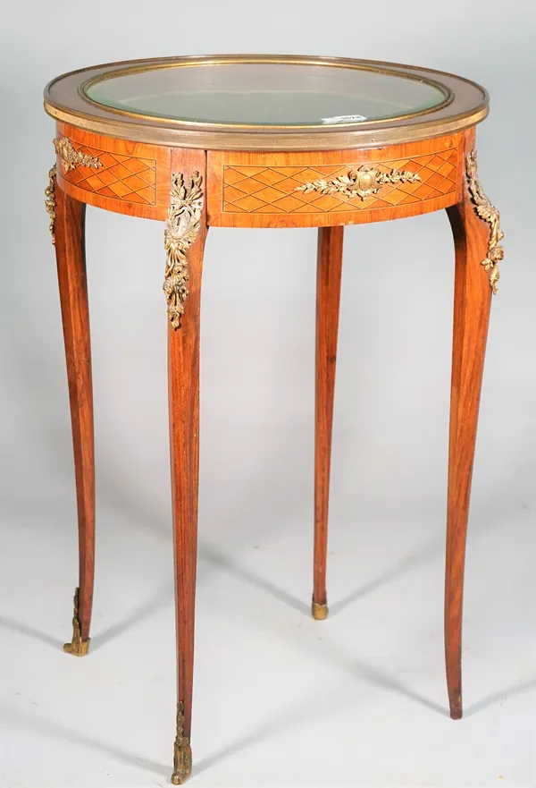 A late 19th century French gilt-metal mounted inlaid kingwood vertu table, the bevelled glass circular lift top on four slender cabriole supports, 53c