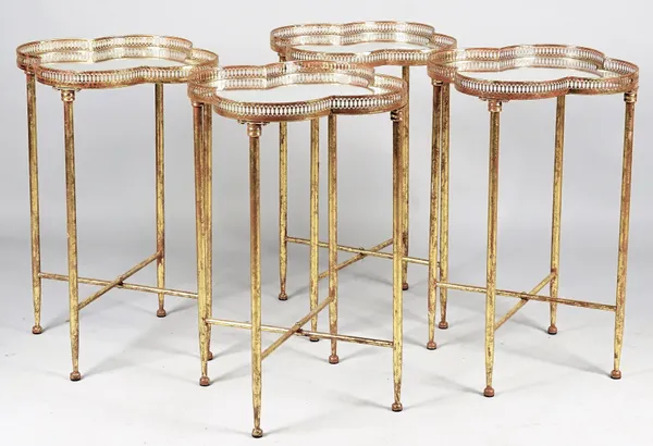 A set of four gilt-metal occasional tables, each with mirrored inset quatrefoil top on turned supports, 45cm wide x 66cm high, (4).