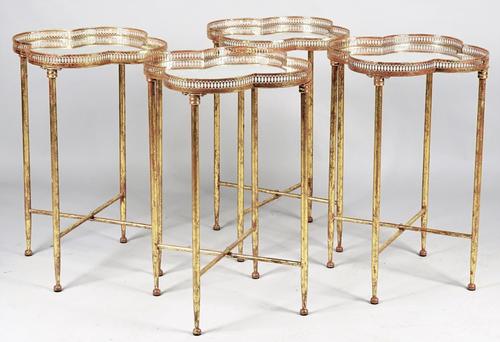 A set of four gilt-metal occasional tables, each with mirrored inset quatrefoil top on turned supports, 45cm wide x 66cm high, (4).