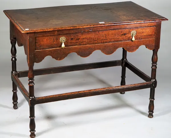 A Queen Anne oak side table with single frieze drawer on turned supports united by high perimeter stretcher, 95cm wide x 72cm high.