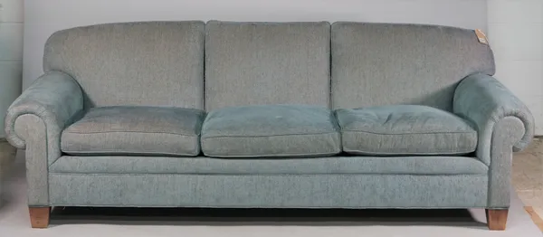 A large modern blue upholstered sofa with roll over arms on tapering block supports, 243cm wide x 87cm high.