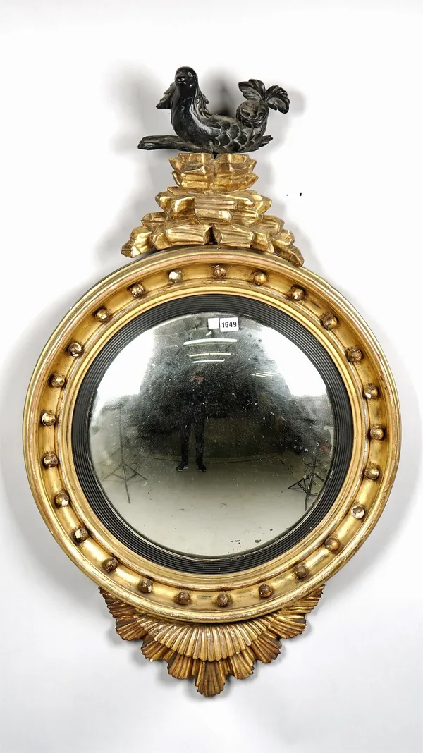 A Regency gilt framed convex mirror with unusual serpent surmount and starburst lower about the reeded ebonised slip, 67cm wide x 113cm high.