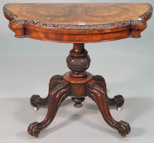 A Victorian figured walnut card table, the pivoting shaped semi elliptic top on carved bulbous column and four downswept supports, 91cm wide x 71cm hi