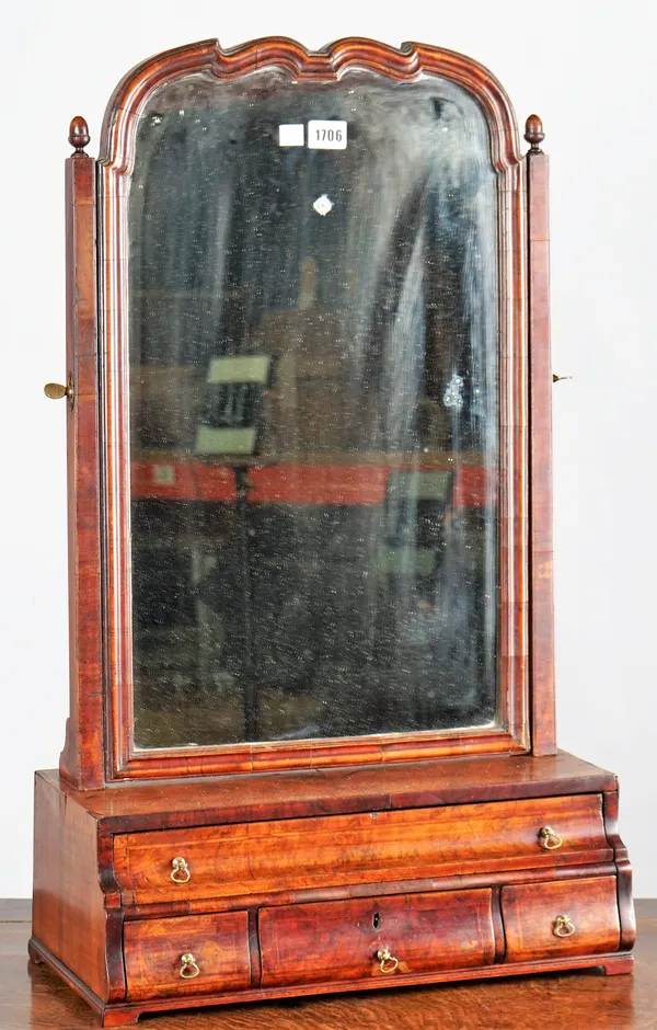 A Queen Anne figured walnut dressing mirror, the shaped plate over a graduated four drawer base, 47cm wide x 78cm high.