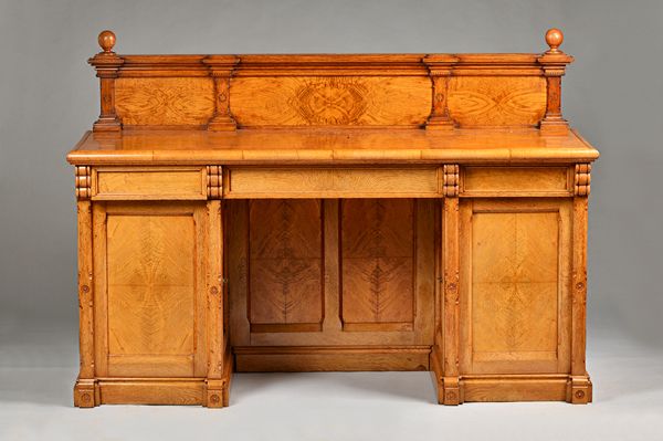 A Victorian Gothic Revival figured oak pedestal sideboard, with three frieze drawers over pair of cupboards, 185cm wide x 130cm high, the underside of