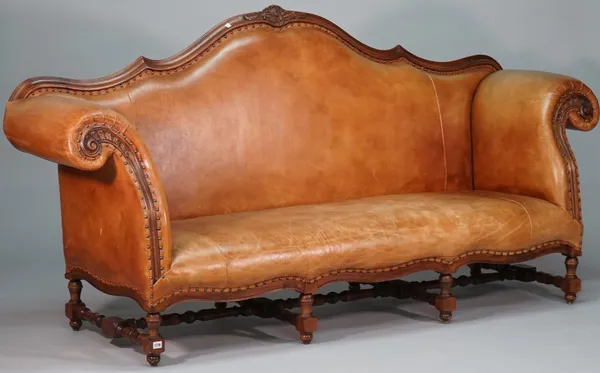 An 18th century Italian style tan leatherette upholstered sofa, with shaped back and frieze and scroll arms on stained beech block and turned supports