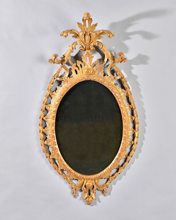 A George III gilt framed mirror with pierced acanthus crest, the oval plate with egg and dart border, 55cm wide x 103cm high. Illustrated