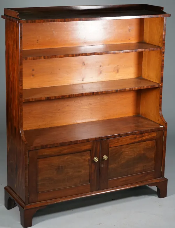 A 19th century mahogany waterfall bookcase with four open tiers over a pair of panel cupboards on bracket feet, 102cm wide x 125cm high.