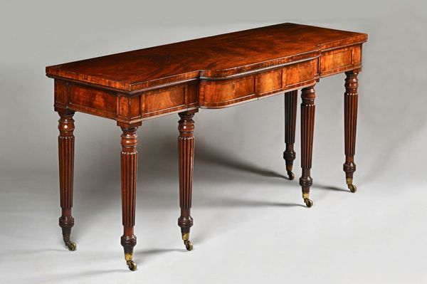 In the manner of Gillows; a George IV mahogany serving table, the breakfront rectangular top with four flush fit frieze drawers on six tapering reeded