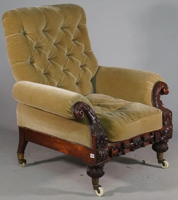 An early Victorian easy armchair with roll over arms and profusely carved mahogany frame, upholstered in Pierre Frey mohair velvet, 98cm wide x 105cm