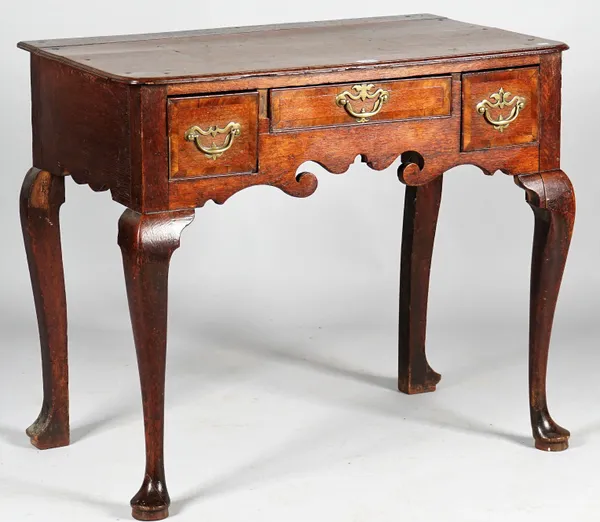 A mid-18th century oak lowboy with three drawers about the shaped frieze resting on pad feet, 81cm wide x 70cm high.