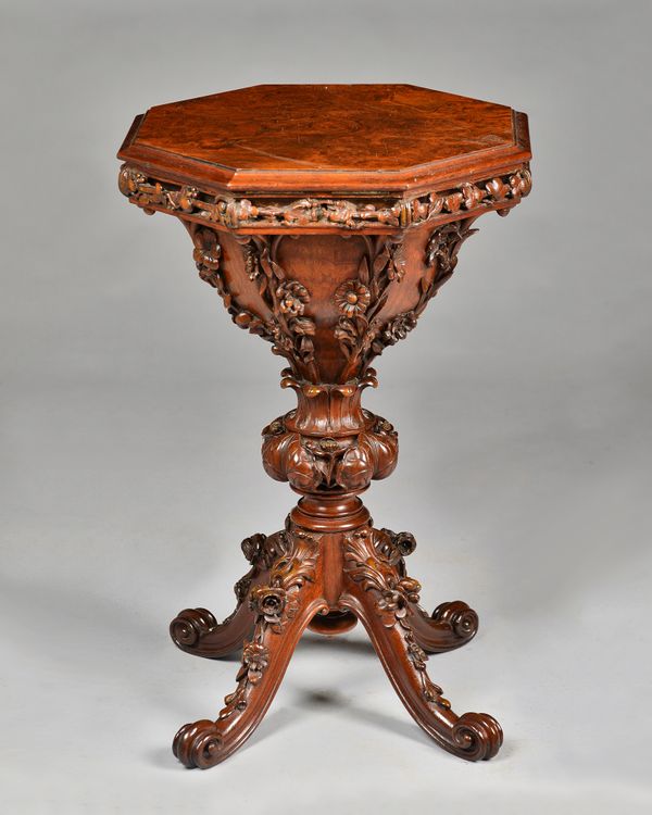 A Victorian figured walnut trumpet shaped work table, the octagonal lift top revealing a fitted birds eye maple interior over relief foliate carved bo