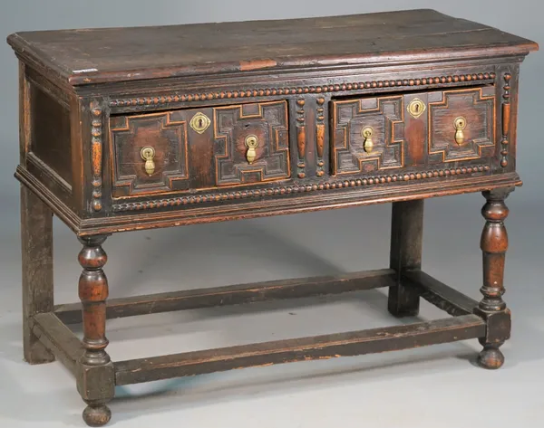 A Charles II and later dresser base with pair of geometric moulded drawers on turned supports united by perimeter stretcher, 114cm wide x 83cm high.