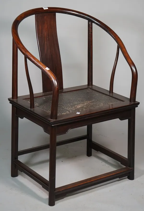 An early 20th century Chinese hardwood horseshoe back armchair with woven seat on rounded supports, 70cm wide x 98cm high.