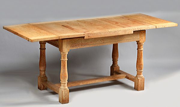 Heals; a limed oak kitchen table, the rectangular drawleaf top on baluster turned supports united by 'H' frame stretcher, 76cm wide x 122cm long x 183